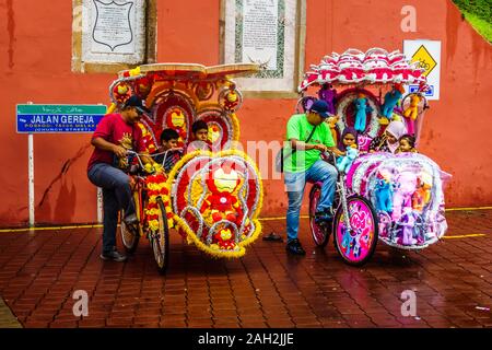 Malacca, Malesia - Dic 15, 2019 : Il decorato in trishaw portano i turisti in giro in piazza olandese Melaka. UNESCO World Heritage Site in Malaysia. Foto Stock