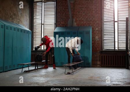 Due gli atleti africani di disimballare le loro borse in spogliatoio che andando in allenamento sportivo Foto Stock