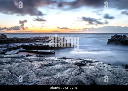 Sunrise oltre la barriera corallina a Sandy Beach Park su Oahu, Hawaii Foto Stock