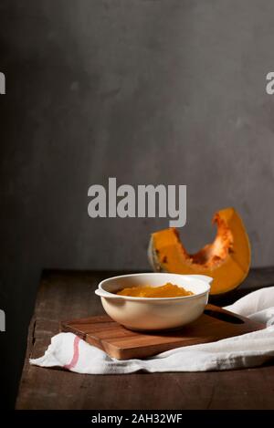 Purea di zucca in una ciotola su sfondo di legno Foto Stock