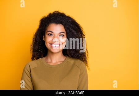 Primo piano della straordinaria piuttosto scuro pelle lady toothy raggiante sorridente adorabili acconciature ondulate indossare pullover casual isolato su giallo colore di sfondo Foto Stock