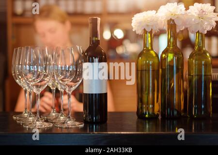 Barista ragazza versa il vino in bicchieri. Ristorante bar, festa del vino Foto Stock