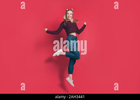 Corpo pieno della foto del profilo di divertenti attraente dama jumping alta gioia in volo usura borgogna maglia pullover e jeans isolato di color pastello di colore rosso Foto Stock