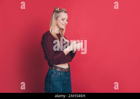 Foto del profilo di influencer lady tenendo il telefono in mano Scrivi commento positivo post sul blog di usura del ponticello a maglia isolato rosso pastello colore di sfondo Foto Stock