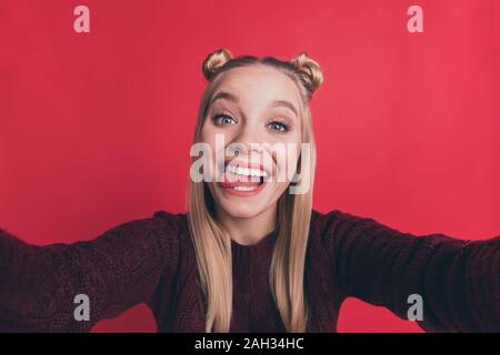 Primo piano della bella signora funny gioventù acconciatura rendendo selfies con la lingua fuori della bocca borgogna indossare pullover a maglia isolato di color pastello di colore rosso Foto Stock