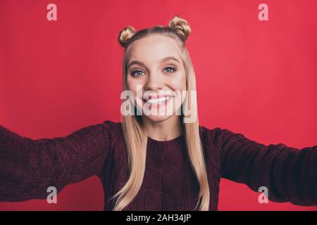 Primo piano della bella signora funny gioventù acconciatura rendendo selfies toothy usura sorridente borgogna pullover a maglia isolato rosso pastello colore di sfondo Foto Stock