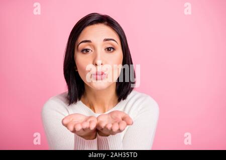 Foto di sorprendente lady tenendo aperte le palme vicino a bocca invio bello ragazzo air kiss indossare pullover bianco rosa isolato colore di sfondo Foto Stock