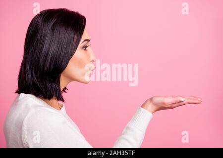 Foto del profilo di sorprendente lady tenendo aperte le palme vicino a bocca invio bello ragazzo air kiss indossare pullover bianco rosa isolato colore di sfondo Foto Stock