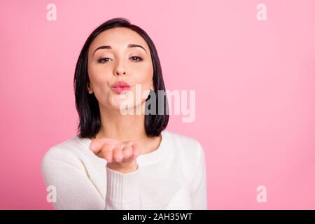 Primo piano della sorprendente lady holding palm vicino a bocca invio bello ragazzo air kiss indossare pullover bianco rosa isolato colore di sfondo Foto Stock