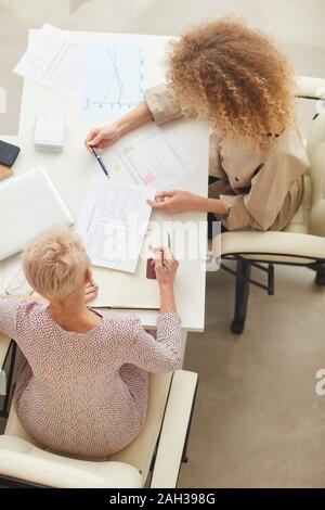 Due irriconoscibile imprenditrici avente disscusion sul nuovo progetto problema verticale sopra da shot Foto Stock