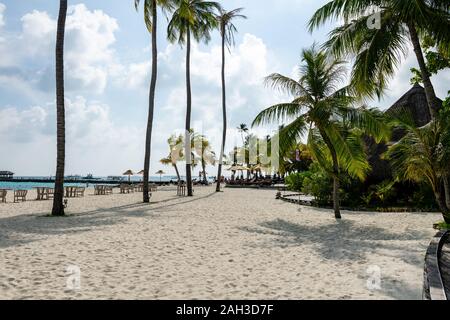 Sdraiato sulla spiaggia di sabbia bianca delle Maldive che si affaccia sul mare turchese Foto Stock