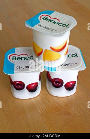 Tre vasetti di yogurt Benecol contenente stanoli vegetali per aiutare ad abbassare il colesterolo per proteggere contro la malattia di cuore coronarica. Foto Stock