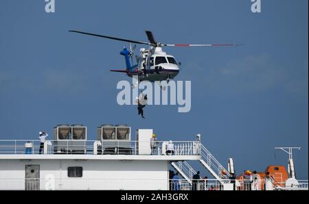 Haikou, cinese della provincia di Hainan. 24 dicembre, 2019. La gente pratica un trapano di salvataggio su navi ro-ro da nave in Haikou, Cina del sud della provincia di Hainan, Dic 24, 2019. Credito: Yang Guanyu/Xinhua/Alamy Live News Foto Stock