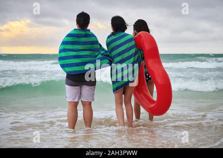 Il Boracay, Aklan Provincia, Filippine - 3 Dicembre 2019: tre donne asiatiche avvolti in teli da spiaggia tenendo un cuore rosso anello e guardare il tramonto Foto Stock