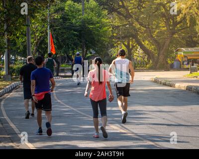 Un sano gruppo di persone per fare jogging e passeggiate su strada in posizione di parcheggio Foto Stock