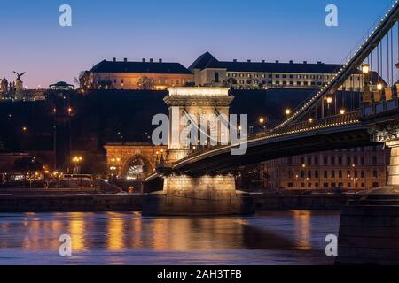 Amazing Photo circa il ponte delle catene di Szechenyi con il fiume Danubio e Sandor palace. Splendida viola le luci del tramonto. Il Sandor Palace è il prim ungherese Foto Stock