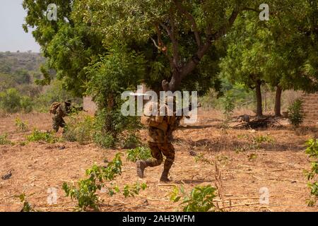 Soldati dell'esercito nigeriano attraversano il cespuglio durante l'addestramento antiterrorismo in Burkina Faso: Febbraio 2019 Foto Stock