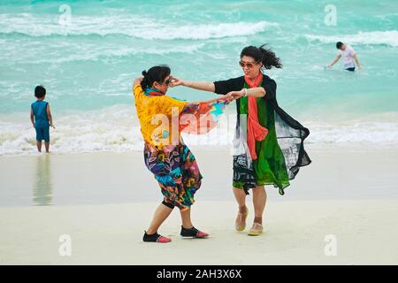 Il Boracay, Aklan Provincia, Filippine - 3 Dicembre 2019: due metà di età donne asiatiche, indossando abiti colorati, godendo di una danza a pulire la spiaggia bianca Foto Stock