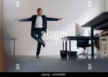 Imprenditore Senior facendo un esercizio di yoga in ufficio Foto Stock