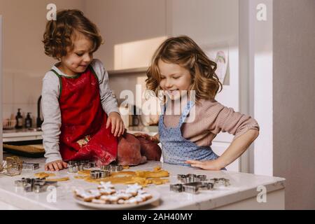 Due ragazze felici la preparazione di biscotti di Natale in cucina Foto Stock