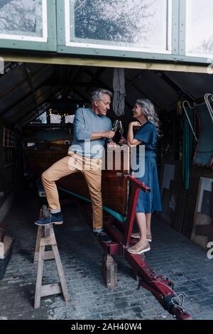 Coppia senior in un tintinnio boathouse bicchieri da champagne Foto Stock
