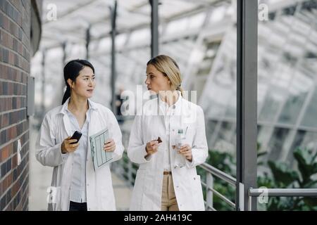 Due medici di sesso femminile parlando in un edificio moderno Foto Stock