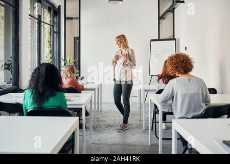 Donna incinta che conduce un workshop in office Foto Stock