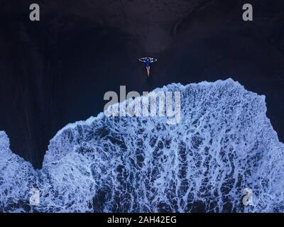 Vista aerea della giovane donna con la tavola da surf in spiaggia, Kedungu Beach, Bali, Indonesia Foto Stock