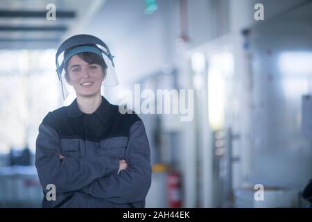 Ritratto di donna tecnico indossa il casco di sicurezza Foto Stock