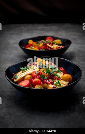 Bocce di Persico con insalata di pomodori e grigliate il formaggio halloumi, melanzana, i semi di melograno, sommacco, sesamo nero e prezzemolo Foto Stock