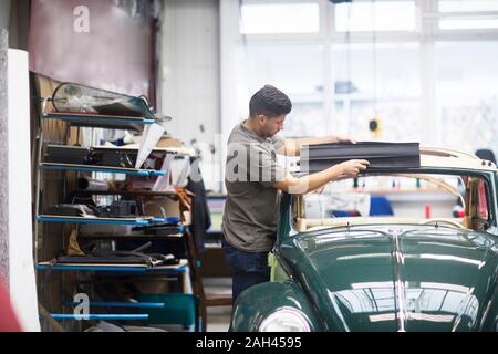 Giovane uomo che lavora in una officina di tappezzeria Foto Stock