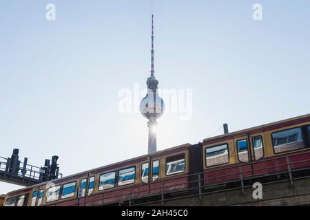 Germania Berlino, basso angolo di visione della TV Tower e i treni di superficie S-Bahn Foto Stock