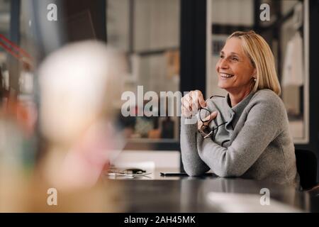 Felice coppia imprenditrice seduto alla scrivania in ufficio Foto Stock