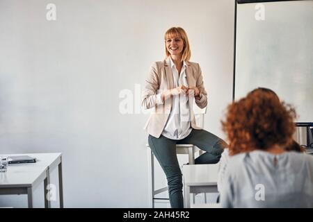 Donna incinta che conduce un workshop in office Foto Stock