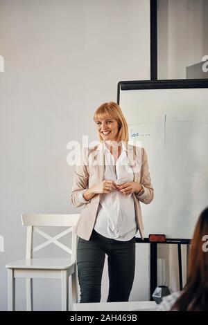 Donna incinta che conduce un workshop in office Foto Stock