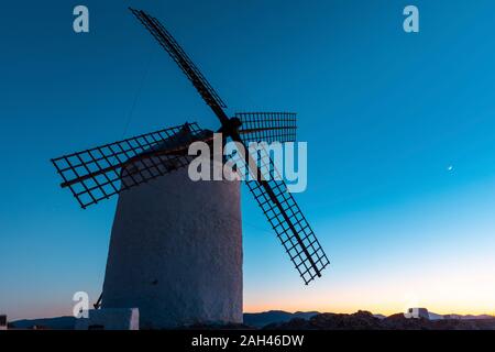 Spagna, provincia di Toledo, Consuegra, antico mulino a vento in piedi contro il cielo al tramonto Foto Stock