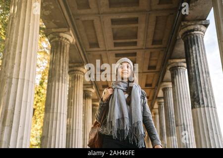 Giovane donna a piedi attraverso una galleria di negozi nella città di Berlino, Germania Foto Stock