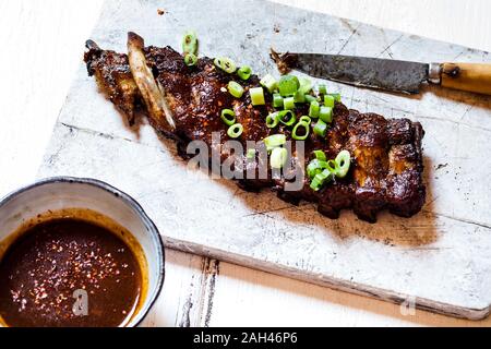 Sticky spareribs con lo scalogno e in casa salsa barbecue Foto Stock