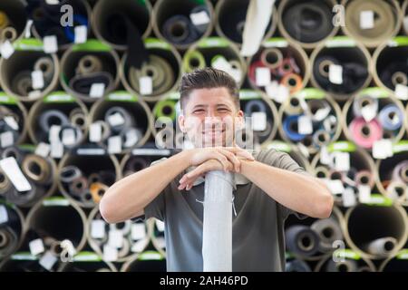 Giovane uomo che lavora in una officina di tappezzeria Foto Stock