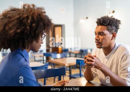 Gli studenti a discutere di un progetto in un cafe Foto Stock