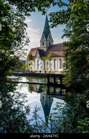 Germania, Baden-Württemberg, Blaubeuren, Blaubeuren Abbey riflettente nel fiume lucido Foto Stock