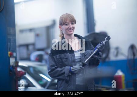 Femmina meccanico auto lavoro in officina di riparazione Foto Stock
