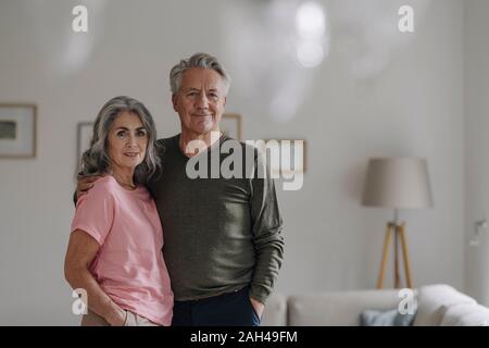 Ritratto di fiducia senior giovane in piedi nel salotto di casa Foto Stock