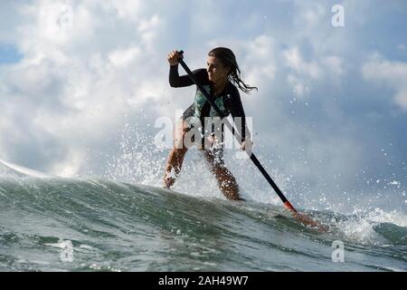 Femmina surfista SUP, Bali, Indonesia Foto Stock