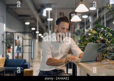 Coppia uomo d affari con computer portatile in ufficio moderno lounge Foto Stock