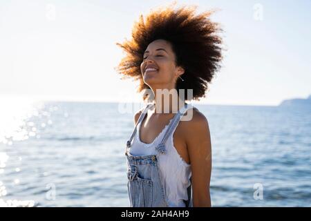 Giovane donna sorridente sulla spiaggia Foto Stock
