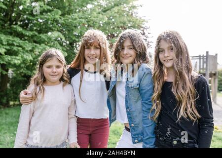 Ritratto di quattro ragazze felici circondato da semi di dente di leone Foto Stock