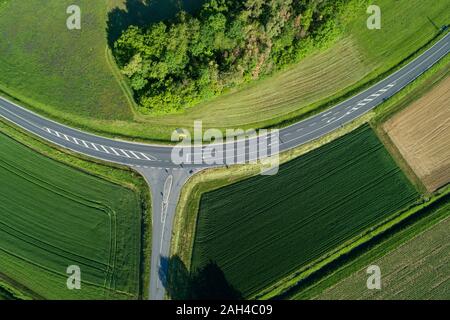 In Germania, in Baviera, vista aerea di campi verdi lungo la strada di campagna in primavera Foto Stock