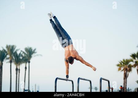 Giovane uomo praticare calisthenics in una palestra a cielo aperto Foto Stock