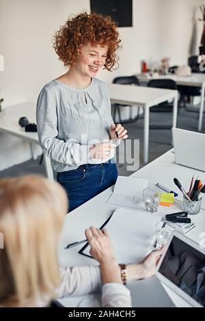 Sorridente imprenditrice che conduce a una riunione in ufficio Foto Stock
